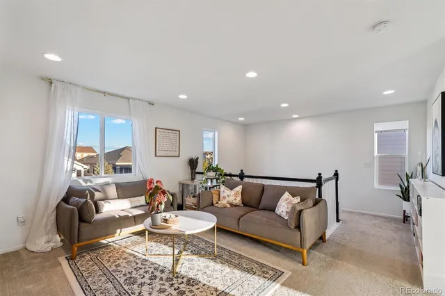 a living room with furniture a rug and a table