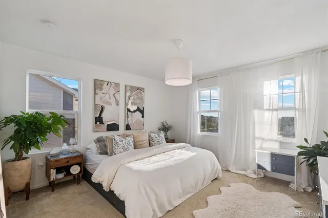 a bedroom with a large bed and a potted plant