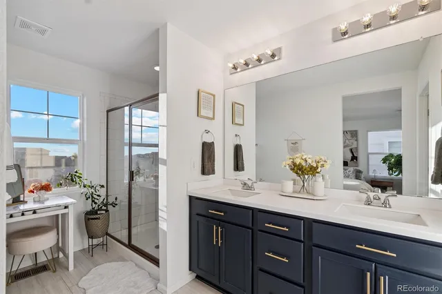 a spacious bathroom with a double vanity sink a mirror and a shower
