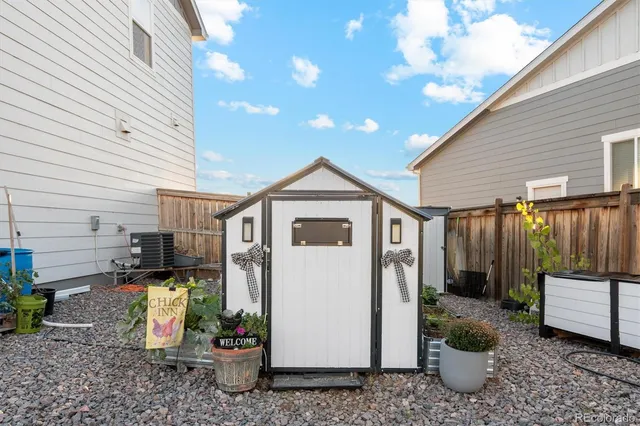 a view of a storage house with yard and sitting area