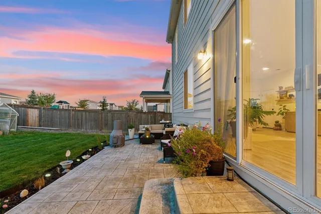 a view of a balcony with chairs and a yard