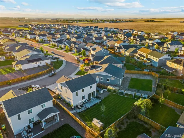 an aerial view of residential houses with outdoor space and ocean view