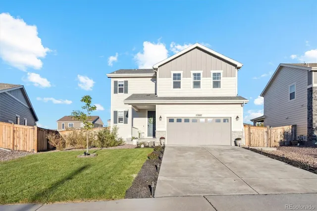a view of a white house with a big yard and large trees