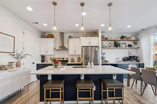 a kitchen with granite countertop a table chairs stove a sink and cabinets