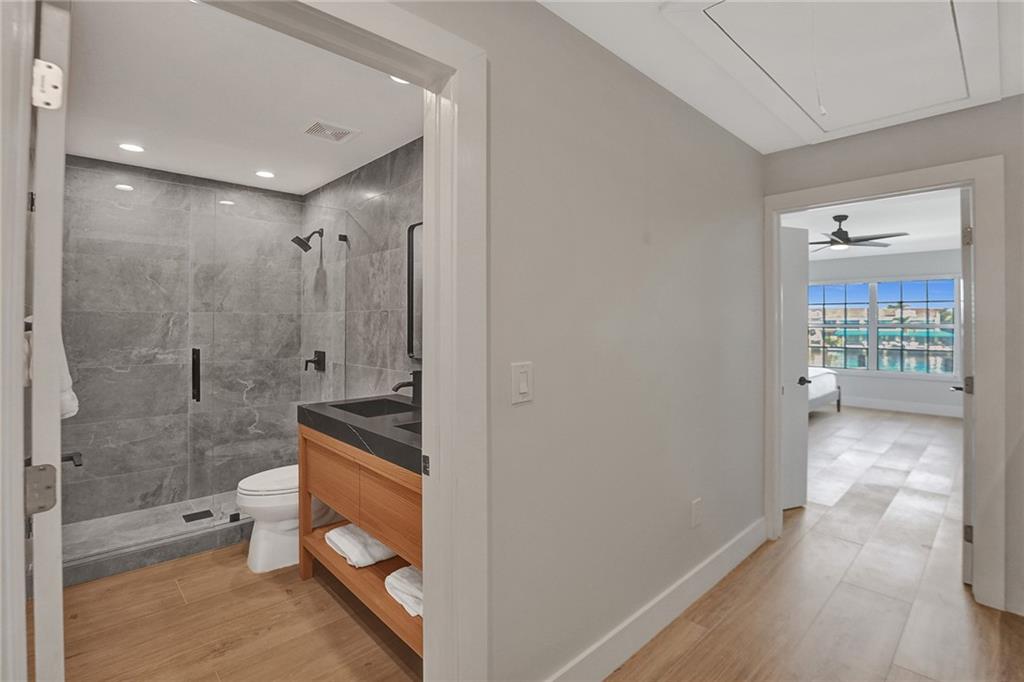 876 Jeffery Street Boca Raton, FL 33487 - Photo 35 of 52 a bathroom with a granite countertop sink a toilet and shower