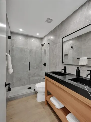 an empty room with wooden floor ceiling fan and windows