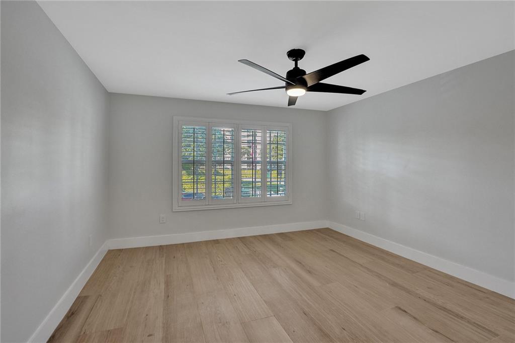876 Jeffery Street Boca Raton, FL 33487 - Photo 38 of 52 an empty room with wooden floor ceiling fan and windows