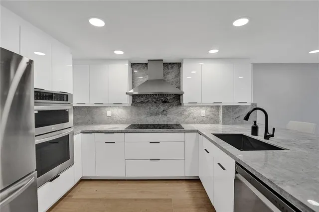 a kitchen with stainless steel appliances granite countertop a sink and stove top oven