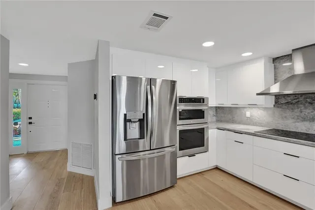 a kitchen with stainless steel appliances a refrigerator sink and microwave