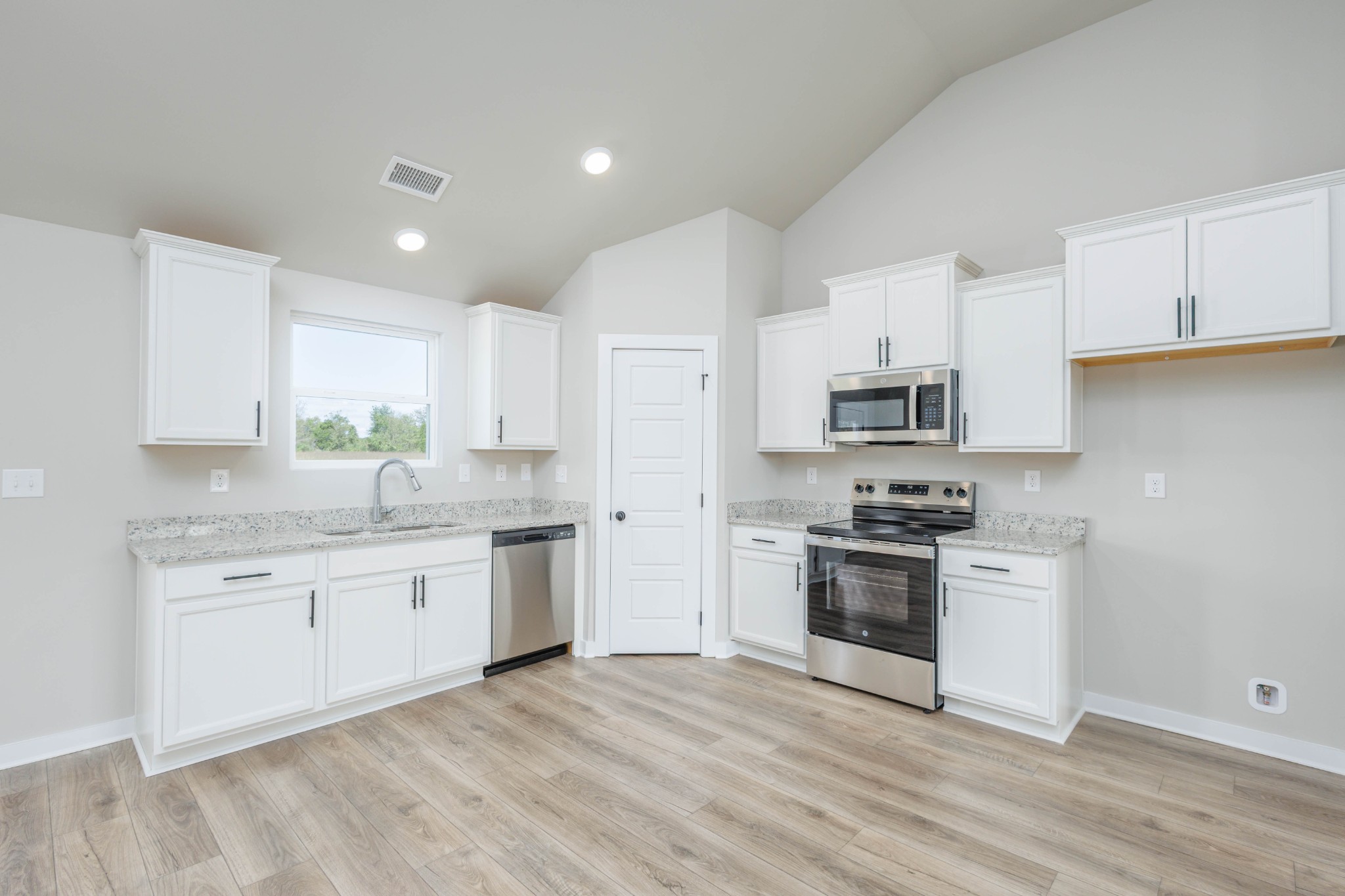 6261 Piney River Road Dickson, TN 37055 - Photo 11 of 32 a kitchen with stainless steel appliances granite countertop a stove top oven a sink and white cabinets