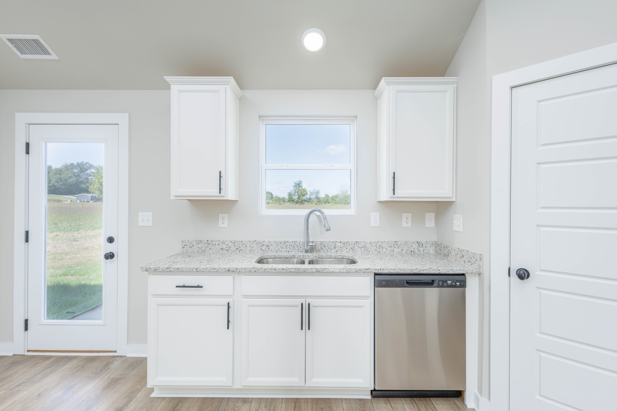 6261 Piney River Road Dickson, TN 37055 - Photo 12 of 32 a kitchen with stainless steel appliances granite countertop white cabinets and window
