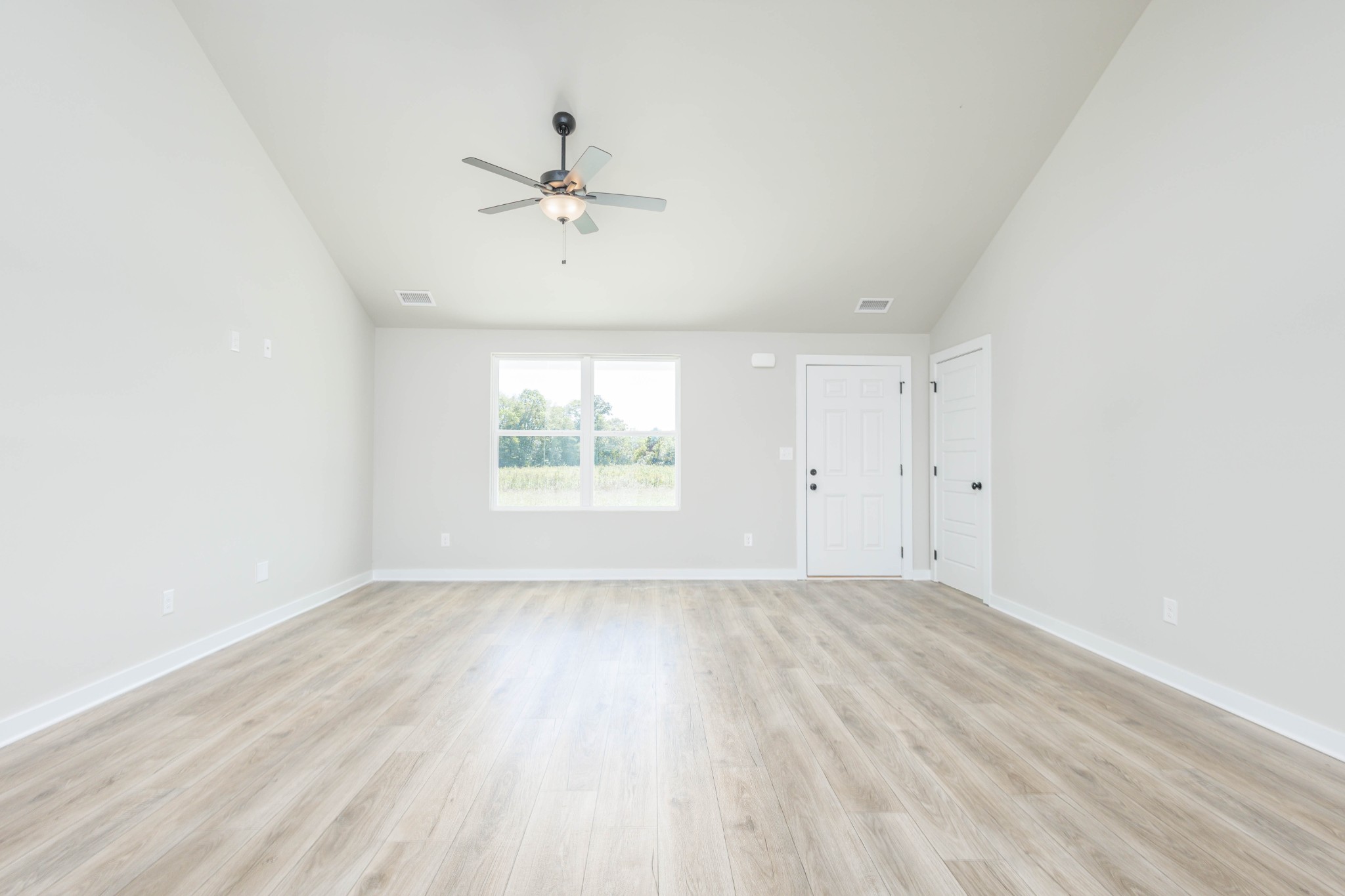 6261 Piney River Road Dickson, TN 37055 - Photo 20 of 32 an empty room with wooden floor fan and windows