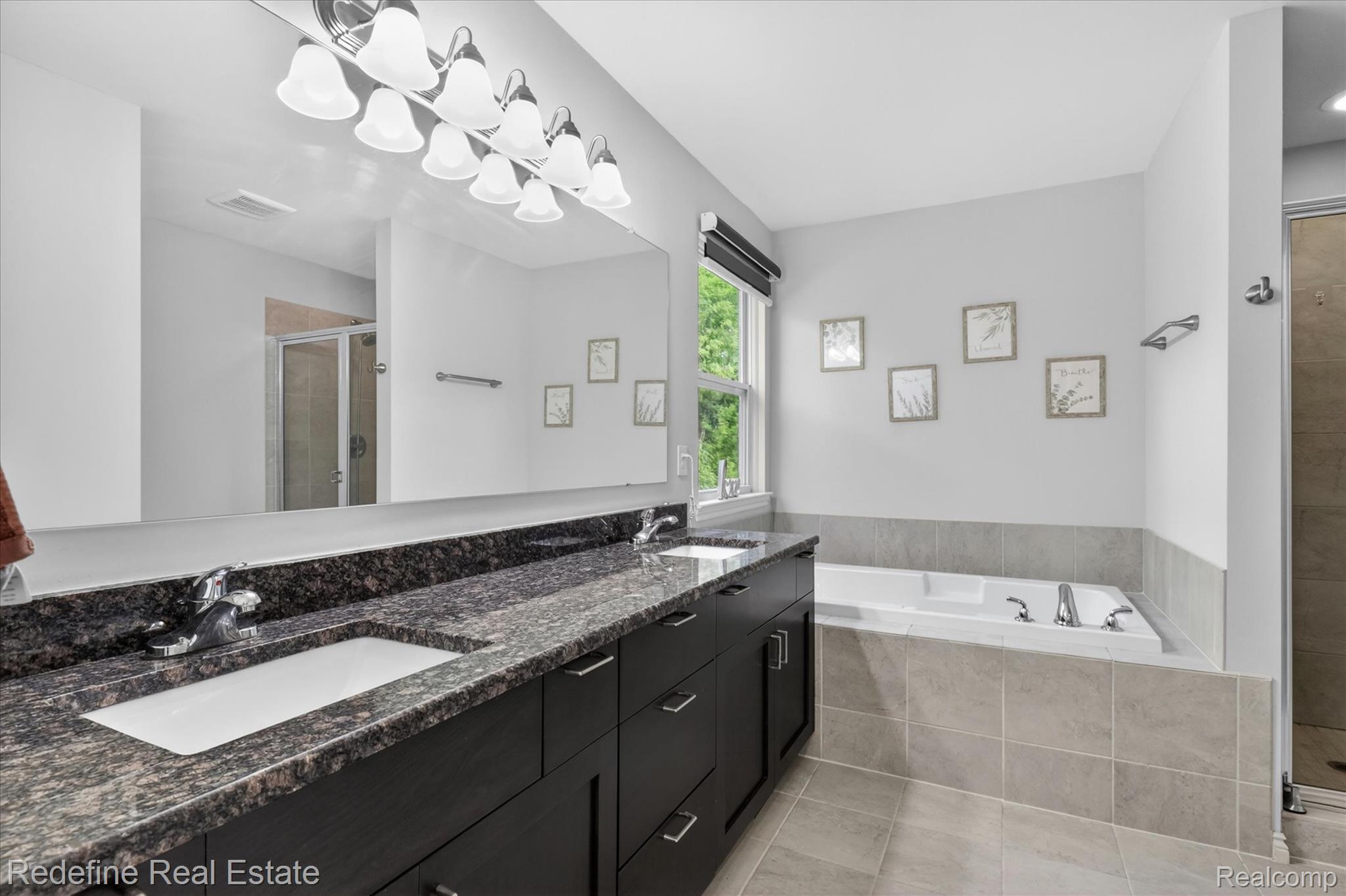 2976 Andlaur Drive Rochester, MI 48307 - Photo 27 of 60 Dual sink vanity featuring dark cabinetry, speckled stone countertop, and chrome fixtures