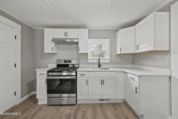 a kitchen with a stove oven and white cabinets