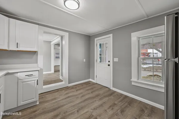 a view of a kitchen with wooden floor and electronic appliances