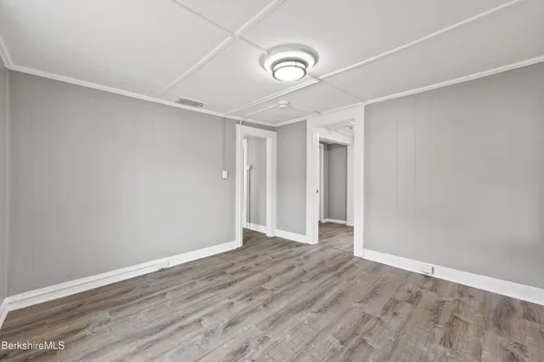 a view of an empty room with wooden floor