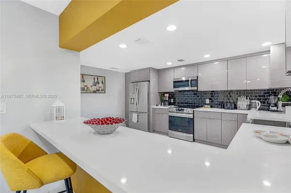 a kitchen with stainless steel appliances a refrigerator sink and microwave
