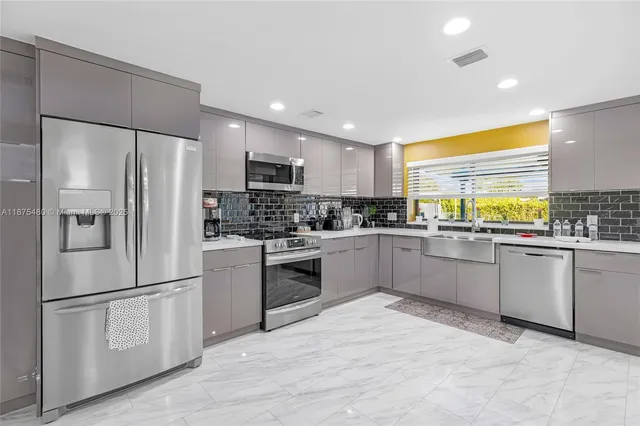 a kitchen with stainless steel appliances a refrigerator sink and microwave