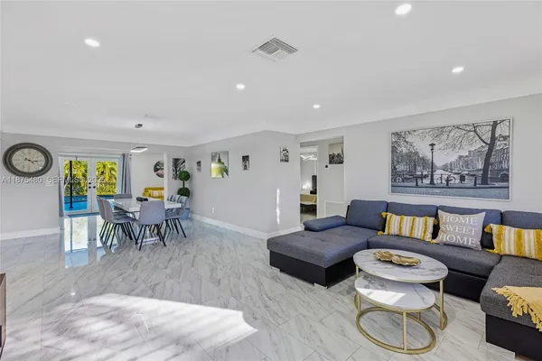 a living room with furniture and a dining table with wooden floor