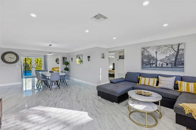 a living room with furniture and a dining table with wooden floor