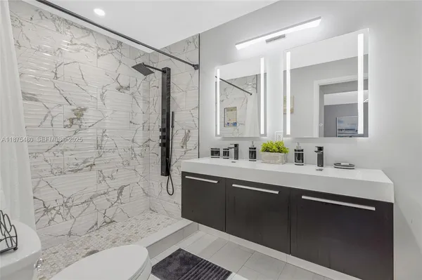 a bathroom with a sink a toilet and shower