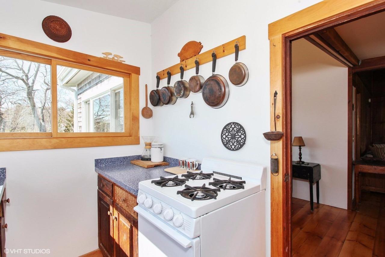 5 Slade Hill Road Truro, MA 02666 - Photo 8 of 15 a white kitchen with a stove and a wooden floor