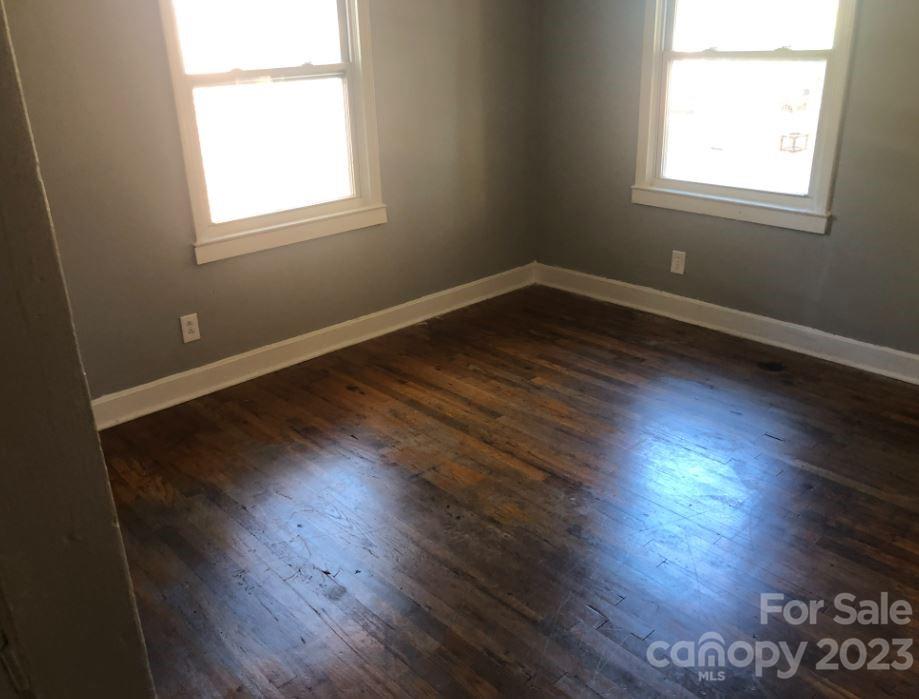 1702 Newland Road Charlotte, NC 28216 - Photo 8 of 34 an empty room with wooden floor and windows