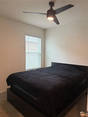 a bedroom with a bed and a ceiling fan