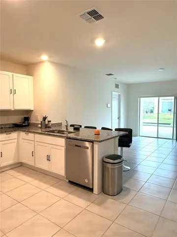 a kitchen with a sink and white cabinets