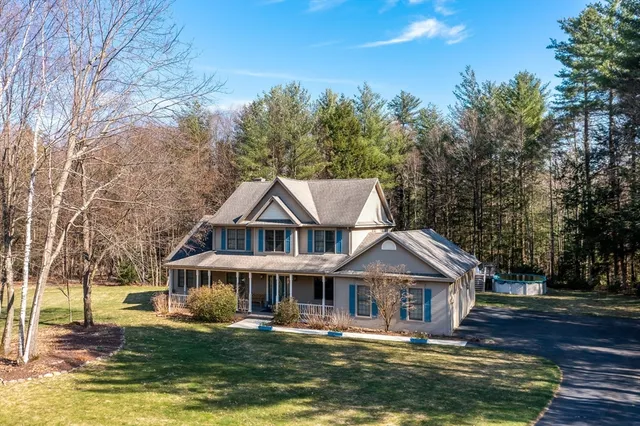 a front view of a house with a garden and trees