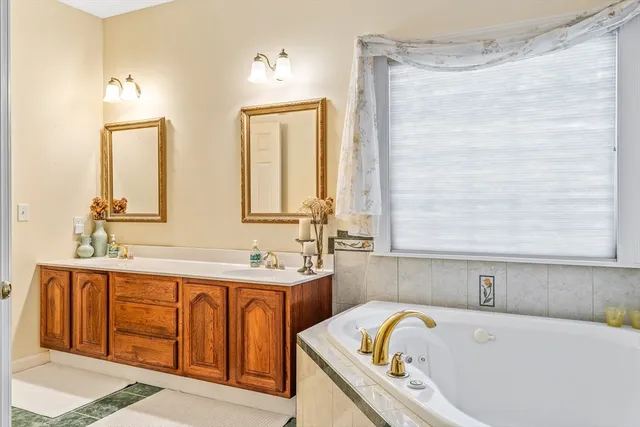 a bathroom with a tub sink and mirror
