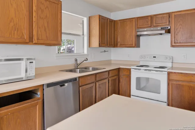 a kitchen with a sink stove and cabinets