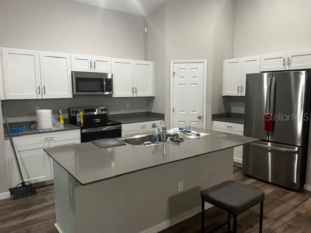 a kitchen with appliances a sink and cabinets