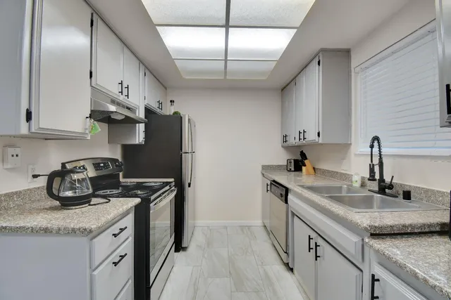 a kitchen with stainless steel appliances granite countertop a sink stove and cabinets