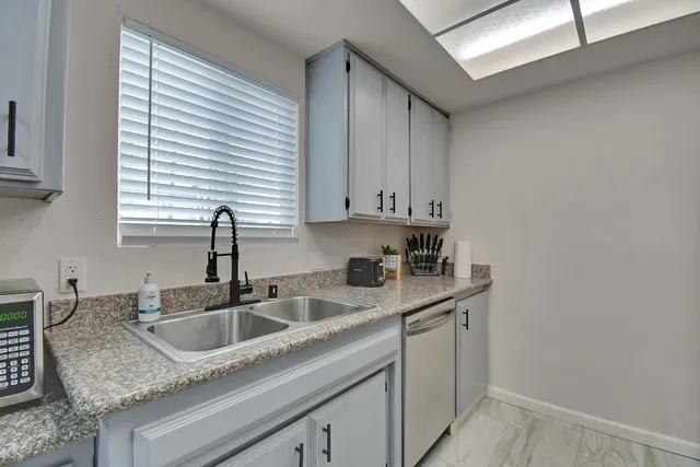 a kitchen with stainless steel appliances granite countertop a sink and a window