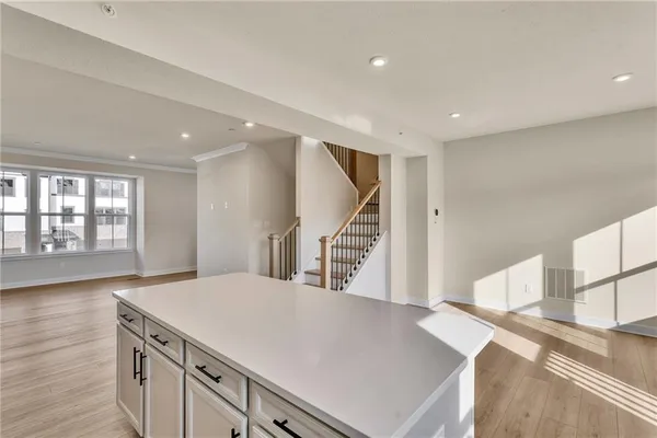 a kitchen with a sink a wooden floor and a large window