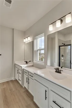 a bathroom with a granite countertop double vanity sink and a mirror