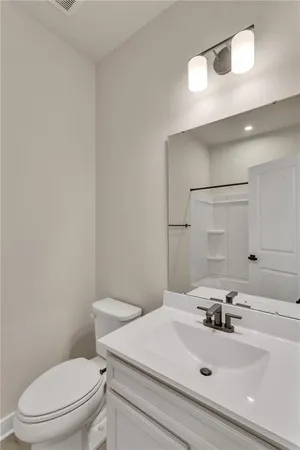 a bathroom with a sink a toilet and mirror