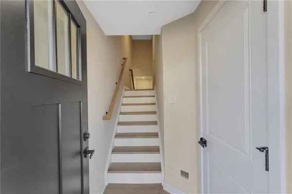 a view of staircase with white walls and white door