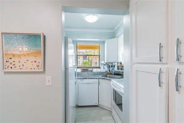 a kitchen with stainless steel appliances granite countertop white cabinets and window