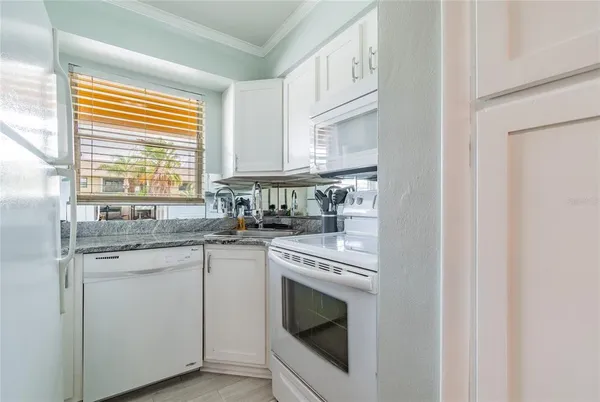 a kitchen with stainless steel appliances granite countertop a sink and a stove