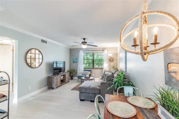 a living room with furniture a chandelier and a window