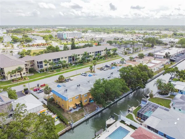 an aerial view of a city with lots of residential buildings ocean and mountain view in back
