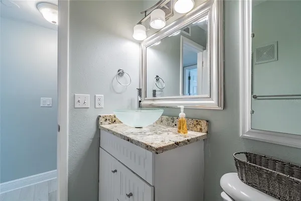 a bathroom with a granite countertop sink and a mirror