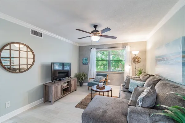 a living room with furniture a flat screen tv and a large window
