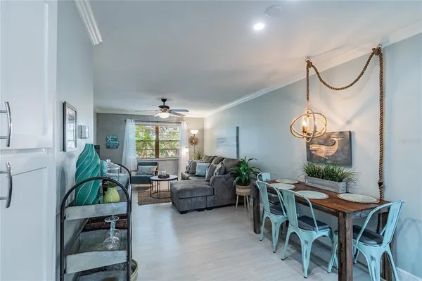 a living room with furniture a chandelier and a dining table