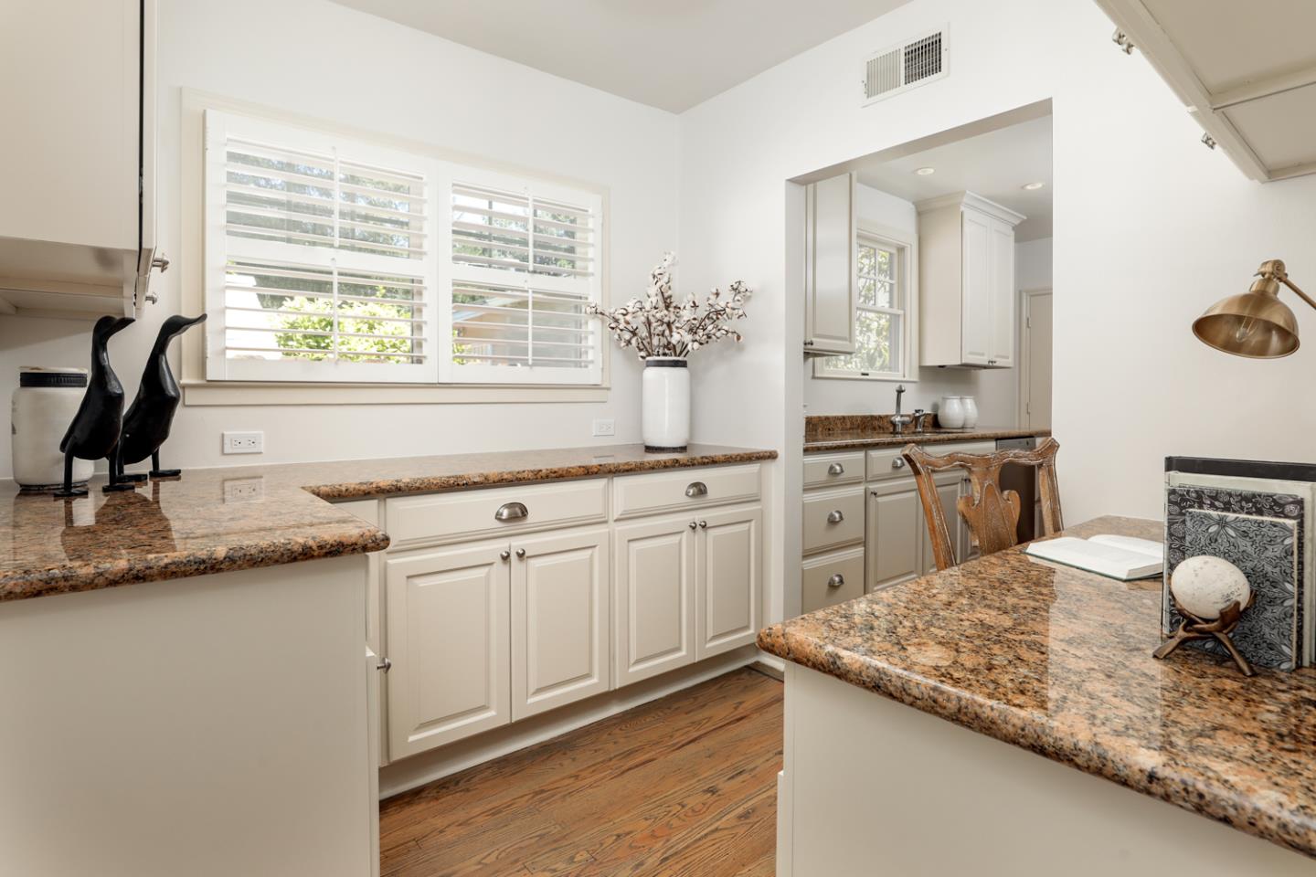 1104 Cambridge Road Burlingame, CA 94010 - Photo 19 of 34 a kitchen with kitchen island granite countertop a sink white cabinets and a granite counter tops