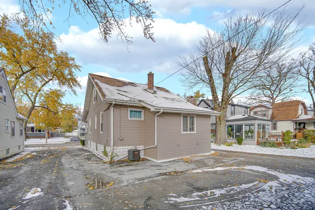 a view of a white house with a large tree