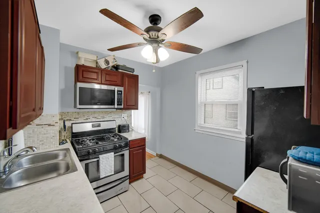 a kitchen with stainless steel appliances a stove a microwave and a sink