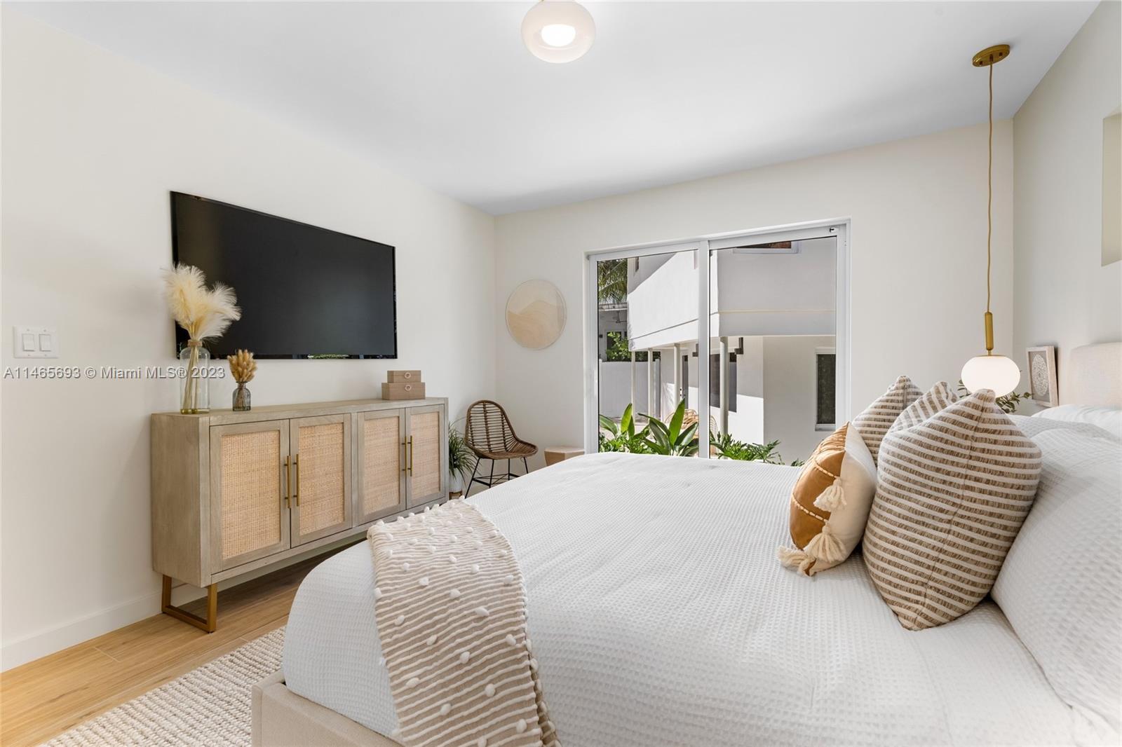 4160 Alton Road Miami Beach, FL 33140 - Photo 11 of 34 a bedroom with a bed and a flat screen tv